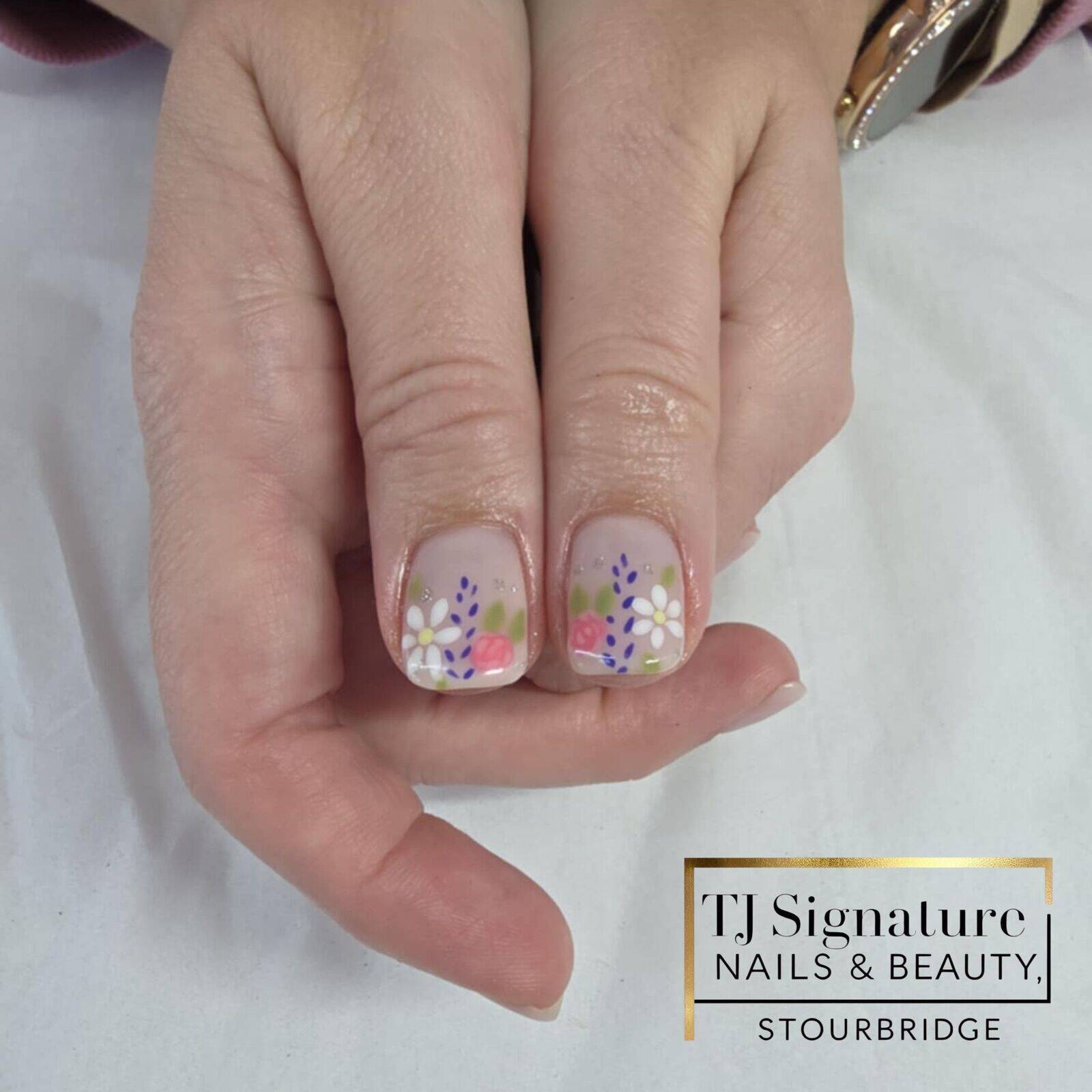 Hand-painted floral nail art on a soft nude base. A fresh, feminine design featuring dainty daisies and pastel blooms – perfect for a natural yet detailed finish.