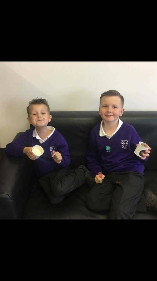 2 happy customers enjoying there Rossi ice cream after being very good boys. 